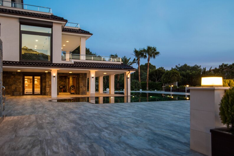 A stunning modern villa with elegant lighting and a spacious outdoor area by top villa construction companies in Bangalore